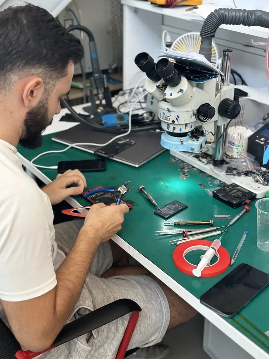 Τεχνικός του iMarket δουλεύει πάνω σε οθόνη iPhone